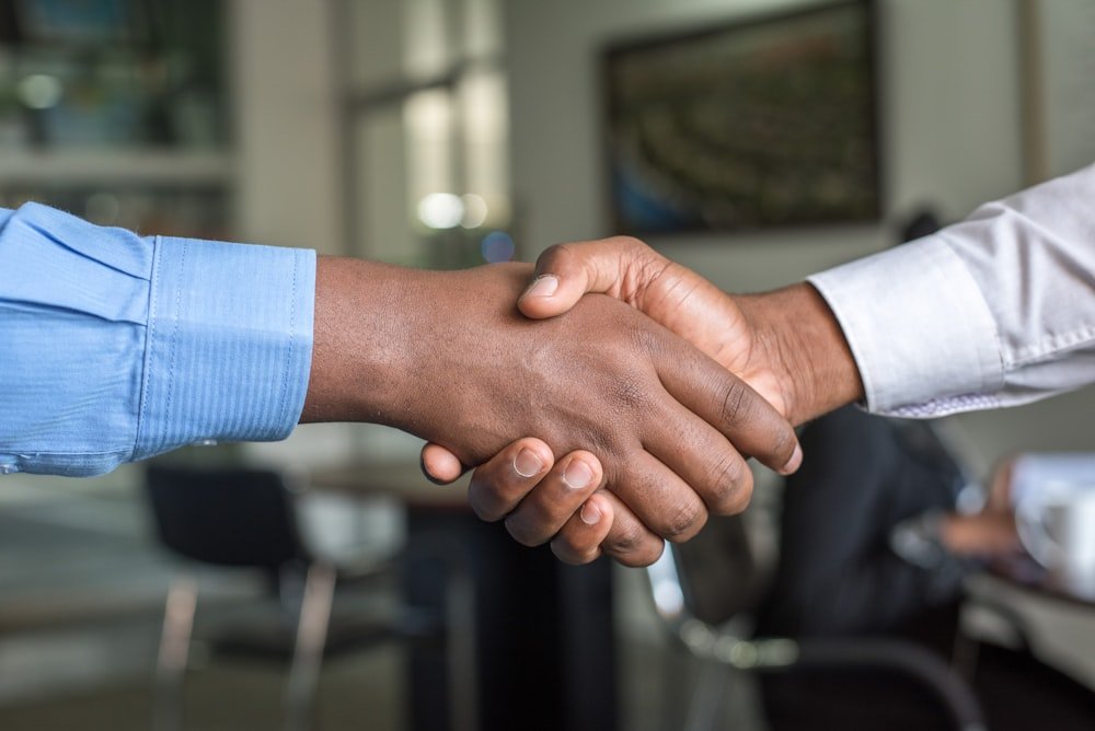 Business handshake representing long-term client commitment